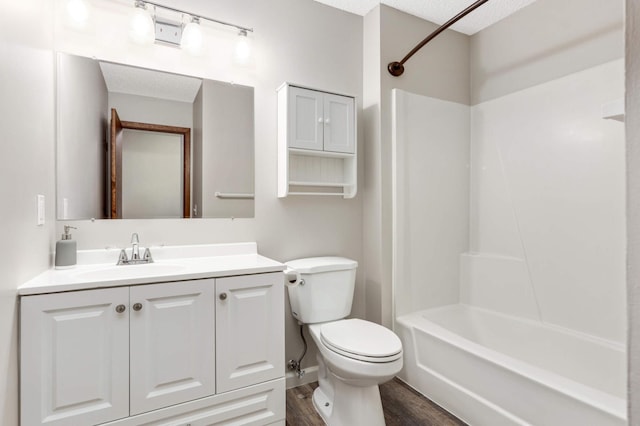 full bathroom featuring toilet, vanity, wood-type flooring, a textured ceiling, and bathtub / shower combination