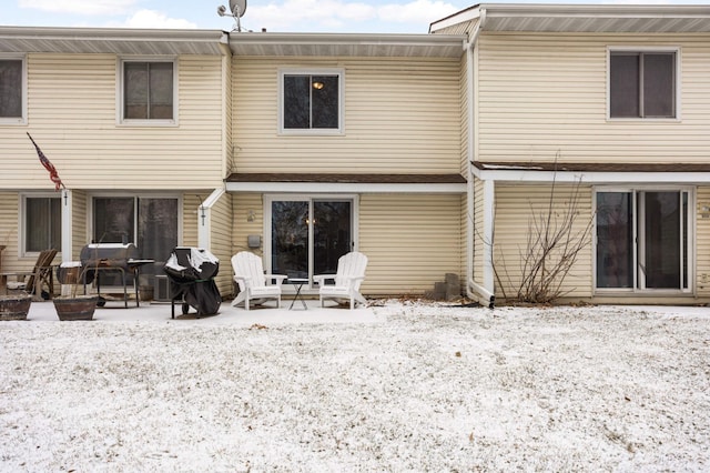 snow covered house featuring a patio