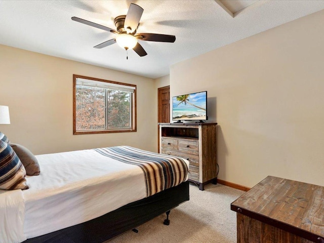 bedroom featuring light carpet, a textured ceiling, and ceiling fan