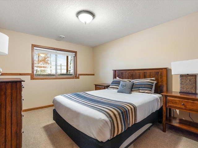 bedroom with light carpet and a textured ceiling