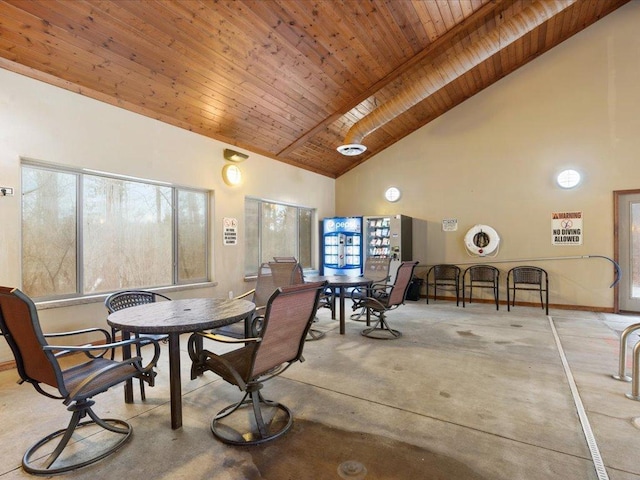 carpeted dining area with wood ceiling and high vaulted ceiling