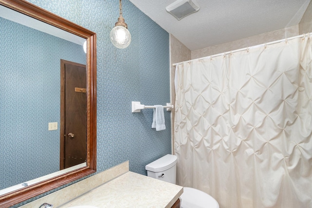 bathroom featuring vanity, toilet, and a textured ceiling