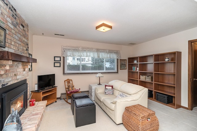 living room featuring a fireplace, light tile patterned floors, and a textured ceiling