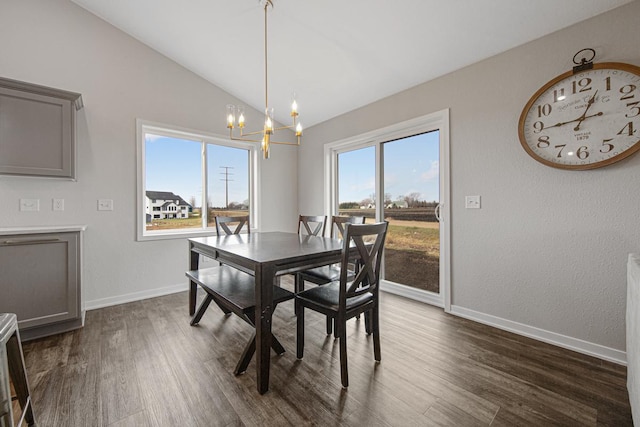 dining room featuring vaulted ceiling, dark hardwood / wood-style floors, and an inviting chandelier