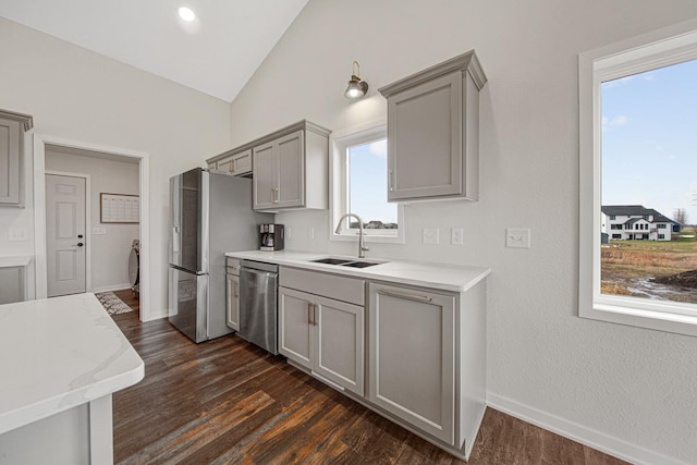 kitchen featuring gray cabinets, sink, lofted ceiling, and stainless steel appliances