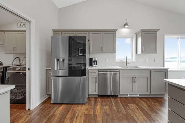 kitchen with gray cabinetry, sink, lofted ceiling, and appliances with stainless steel finishes