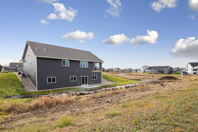 rear view of property with a lawn, a patio, and central AC unit