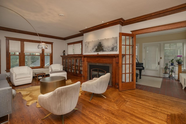 living room featuring ornamental molding, radiator, a fireplace, and wood finished floors