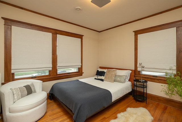 bedroom featuring ornamental molding, baseboards, and hardwood / wood-style floors