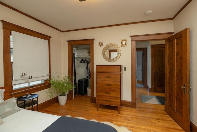 bedroom with baseboards, wood finished floors, and crown molding