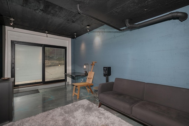 living room featuring finished concrete flooring and concrete block wall