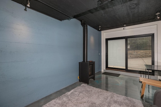 bedroom with a wood stove and concrete flooring