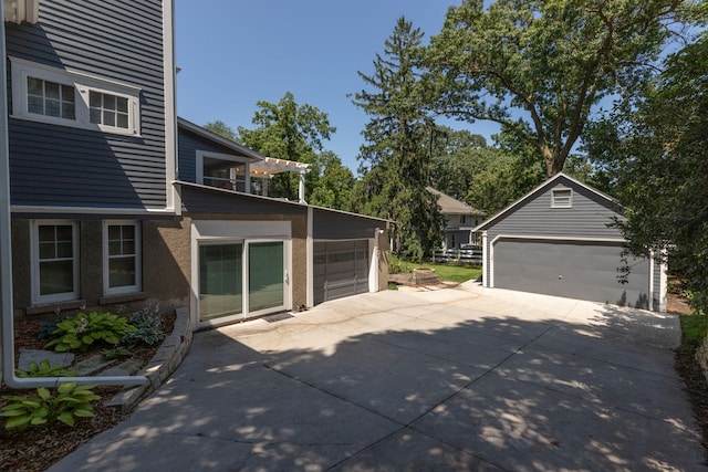 view of side of home featuring a garage and an outbuilding