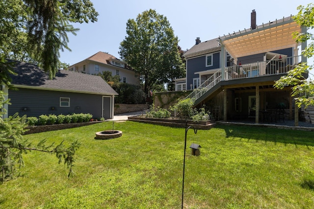 view of yard with stairs, a fire pit, and a wooden deck