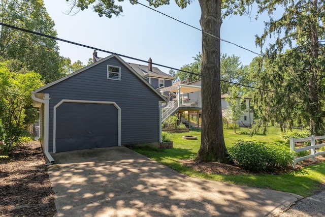 view of home's exterior with concrete driveway, stairway, fence, and a lawn