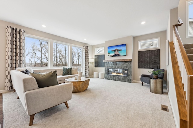 living room featuring a tiled fireplace and carpet floors