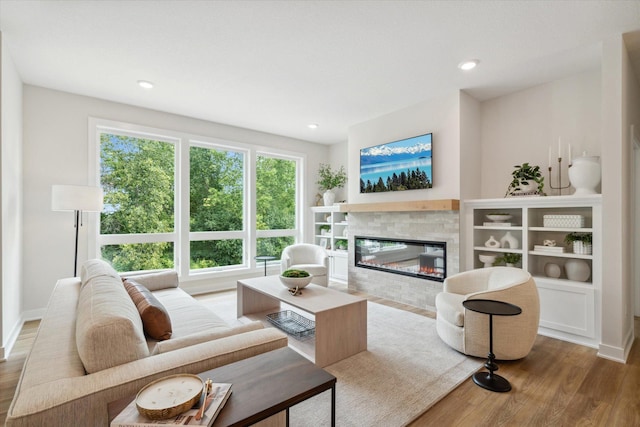 living room featuring a tile fireplace and hardwood / wood-style floors