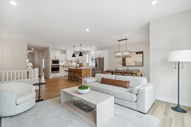 living room featuring light hardwood / wood-style floors and a chandelier