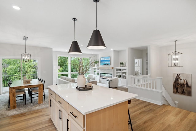 kitchen featuring pendant lighting, a kitchen island, light wood-type flooring, and light brown cabinetry