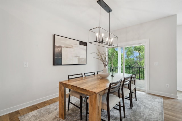 dining space with wood-type flooring and a chandelier