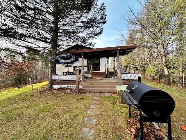 deck featuring a grill and a yard