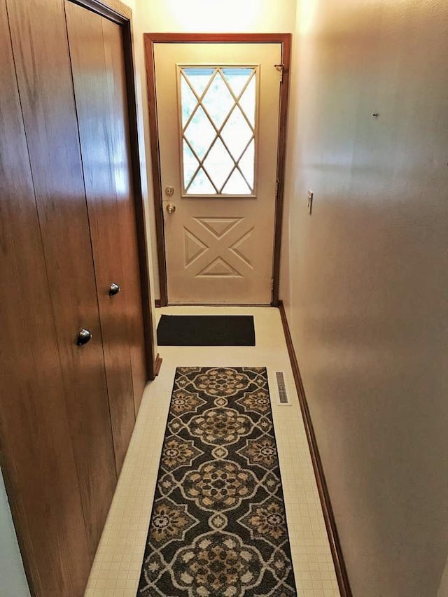 doorway to outside featuring light tile patterned floors and visible vents