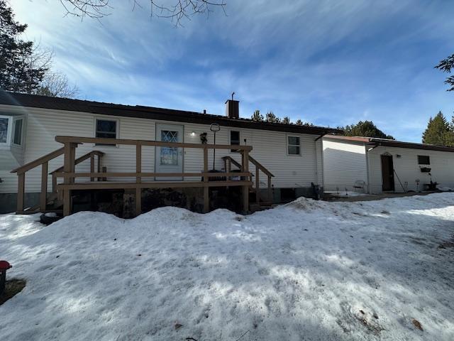 snow covered property with a wooden deck