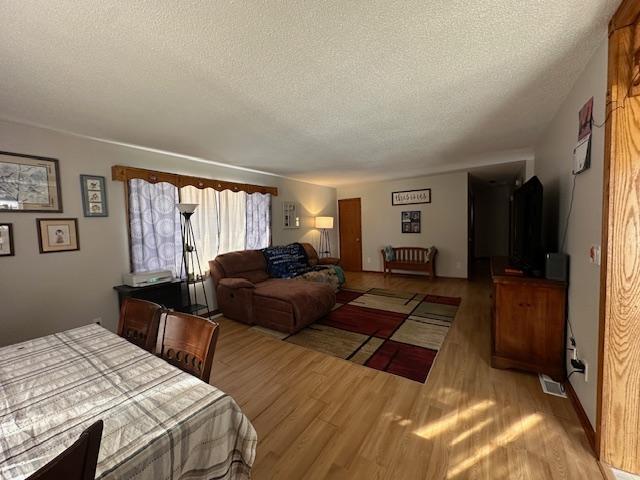 bedroom featuring a textured ceiling, wood finished floors, and visible vents