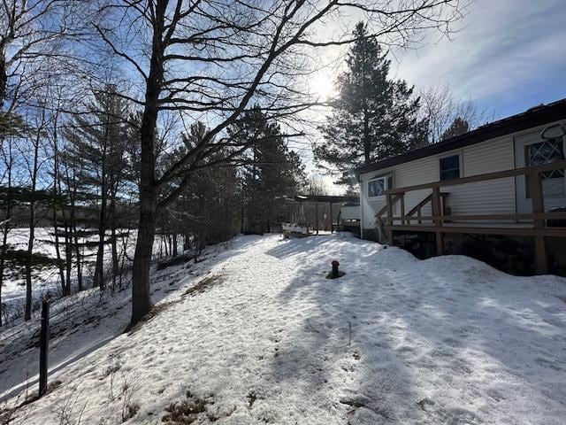 snowy yard featuring a wooden deck