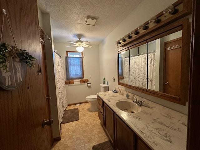 full bath featuring a textured ceiling, toilet, vanity, a ceiling fan, and a shower with curtain