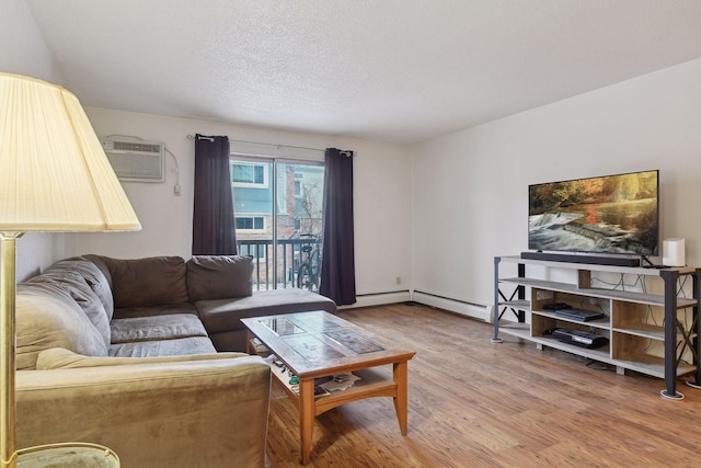 living room featuring a textured ceiling, wood-type flooring, and a wall mounted AC