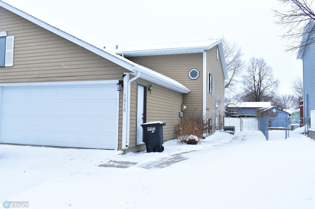 view of snowy exterior featuring a garage