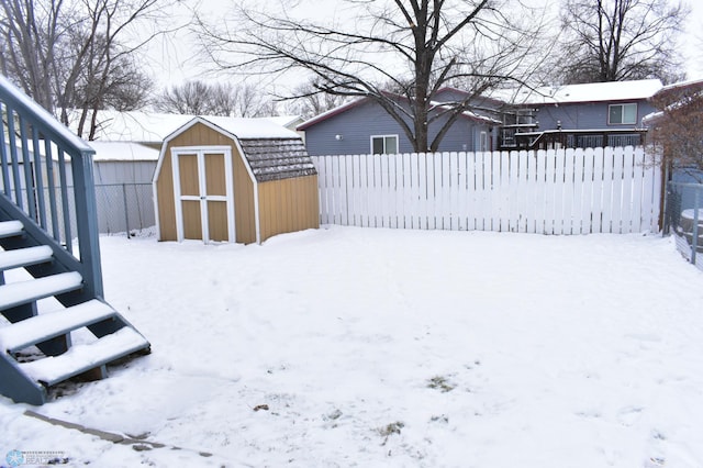 yard covered in snow featuring a shed