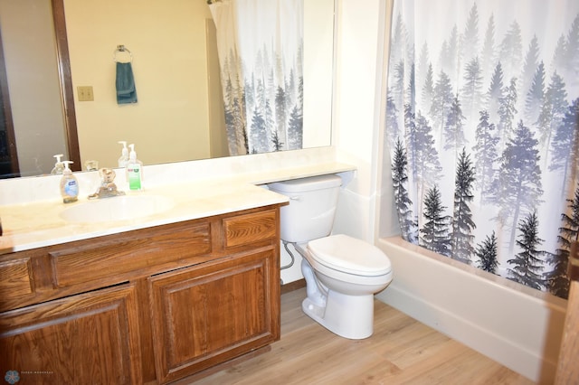 full bathroom with shower / bath combo, vanity, hardwood / wood-style flooring, and toilet