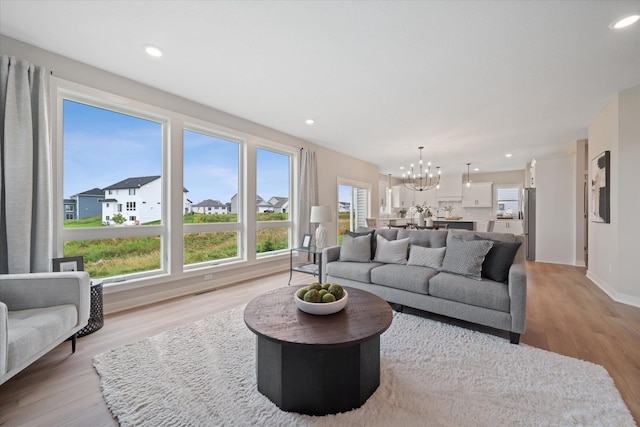 living room featuring a chandelier and light hardwood / wood-style flooring