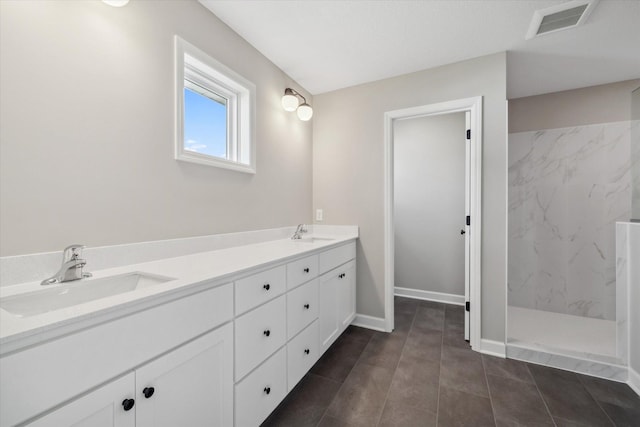 bathroom featuring a tile shower and vanity