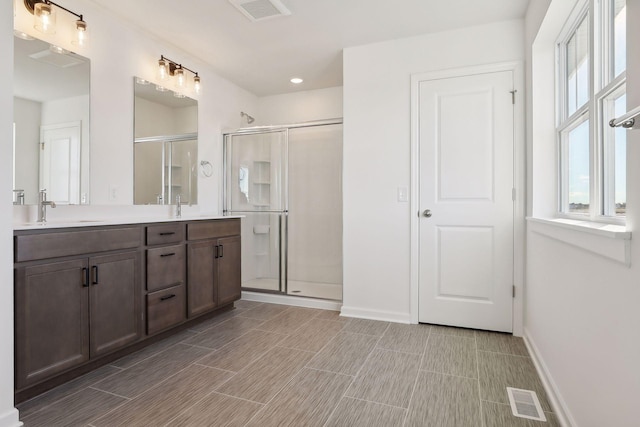 bathroom with a shower with door and vanity