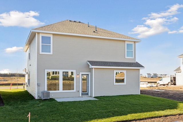 rear view of property with a yard and central AC unit