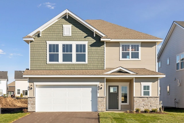 craftsman-style house featuring a front lawn and a garage