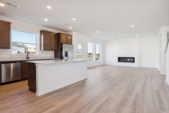 kitchen with a center island, light hardwood / wood-style flooring, stainless steel appliances, and sink