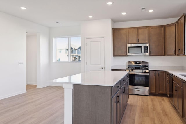 kitchen with a kitchen island, light wood-type flooring, and stainless steel appliances