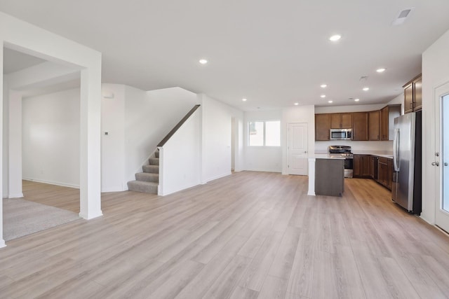 kitchen featuring a kitchen island, light wood-type flooring, and appliances with stainless steel finishes