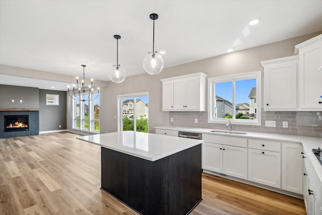 kitchen with white cabinets, sink, hanging light fixtures, plenty of natural light, and a kitchen island