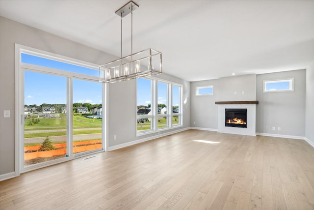 unfurnished living room with a wealth of natural light and light hardwood / wood-style flooring