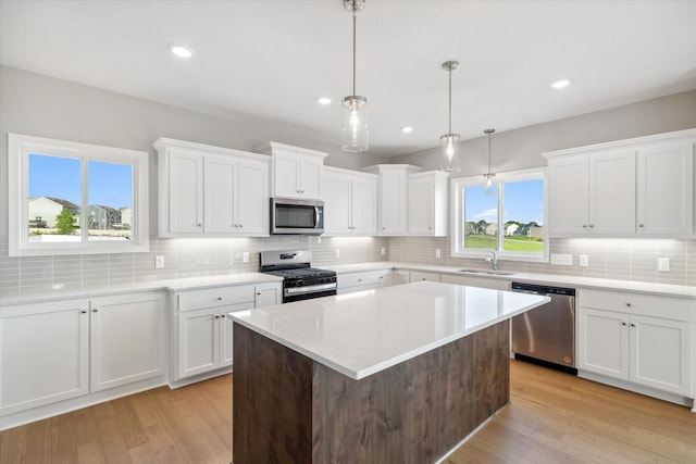 kitchen featuring sink, white cabinets, light wood-type flooring, and appliances with stainless steel finishes