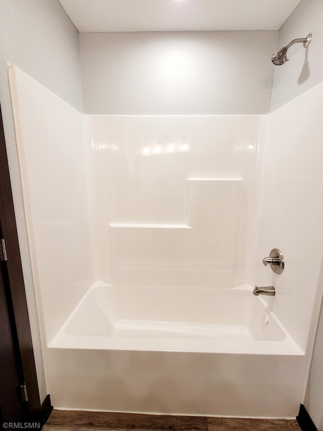 bathroom featuring wood-type flooring and tub / shower combination