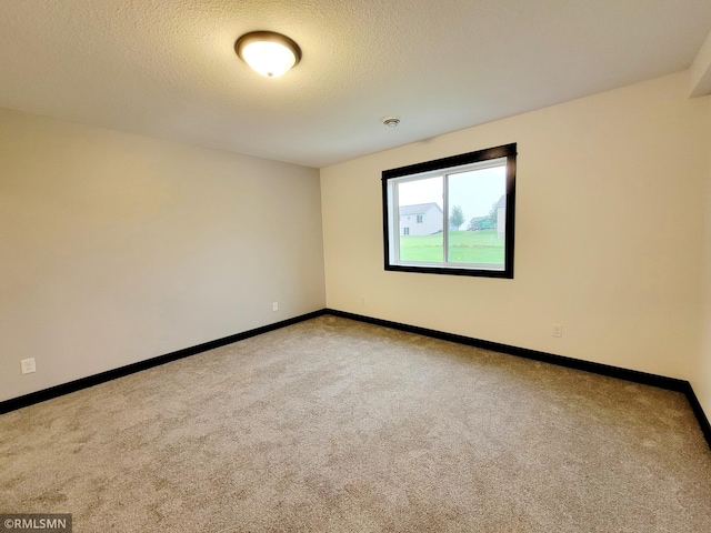 empty room featuring carpet floors and a textured ceiling