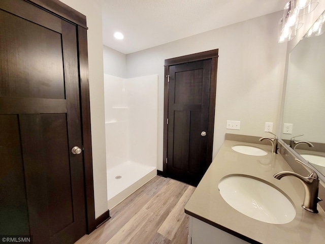 bathroom featuring a shower, wood-type flooring, and vanity