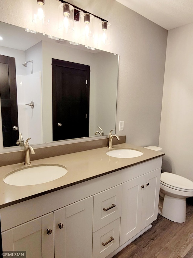 bathroom featuring vanity, toilet, wood-type flooring, and walk in shower