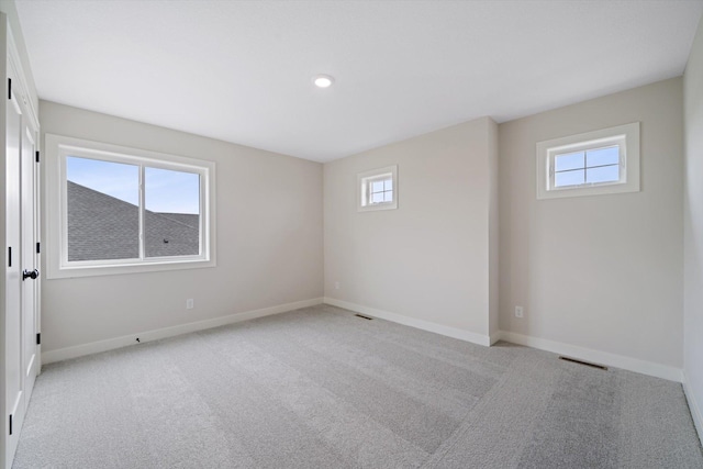 carpeted empty room featuring a wealth of natural light